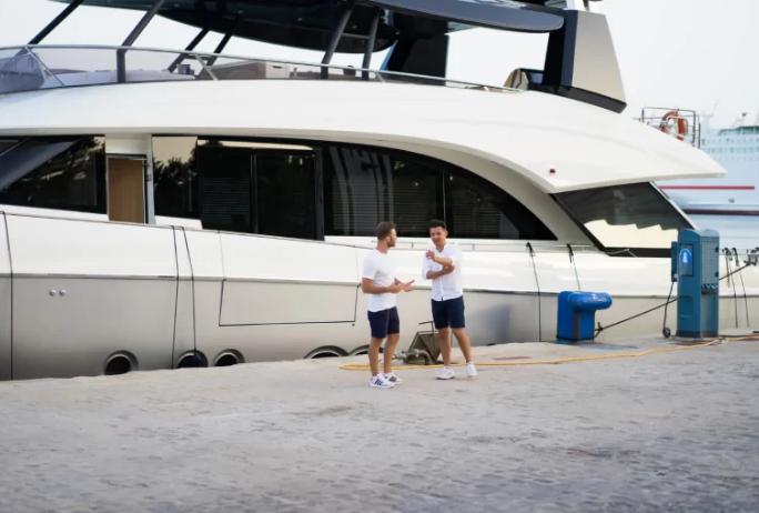 yacht detailing professionals standing near a docked yacht at a marina