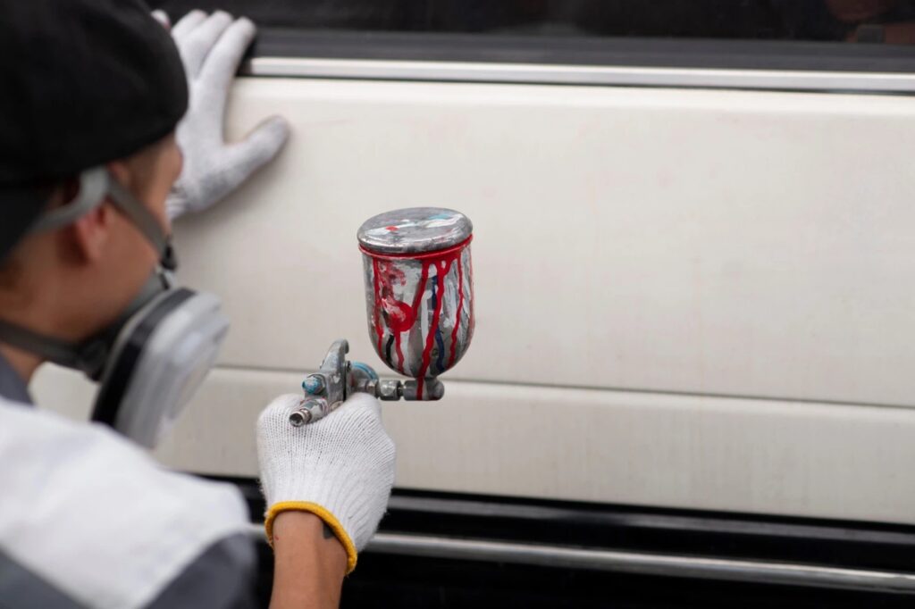 technician applying spray coating during the yacht paint correction process